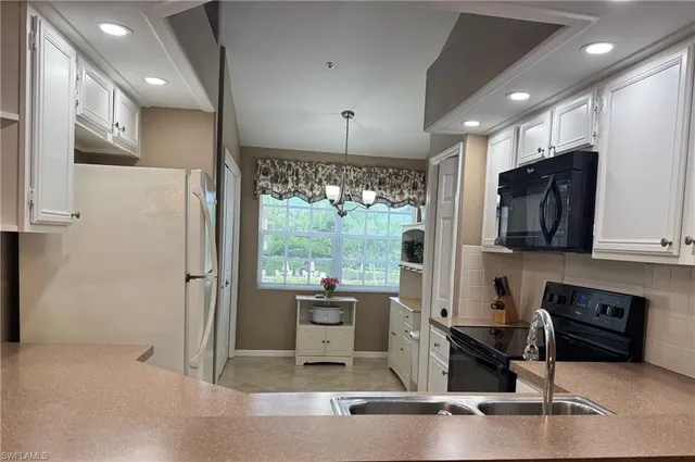 a kitchen with stainless steel appliances granite countertop a refrigerator a stove and a sink with wooden floor