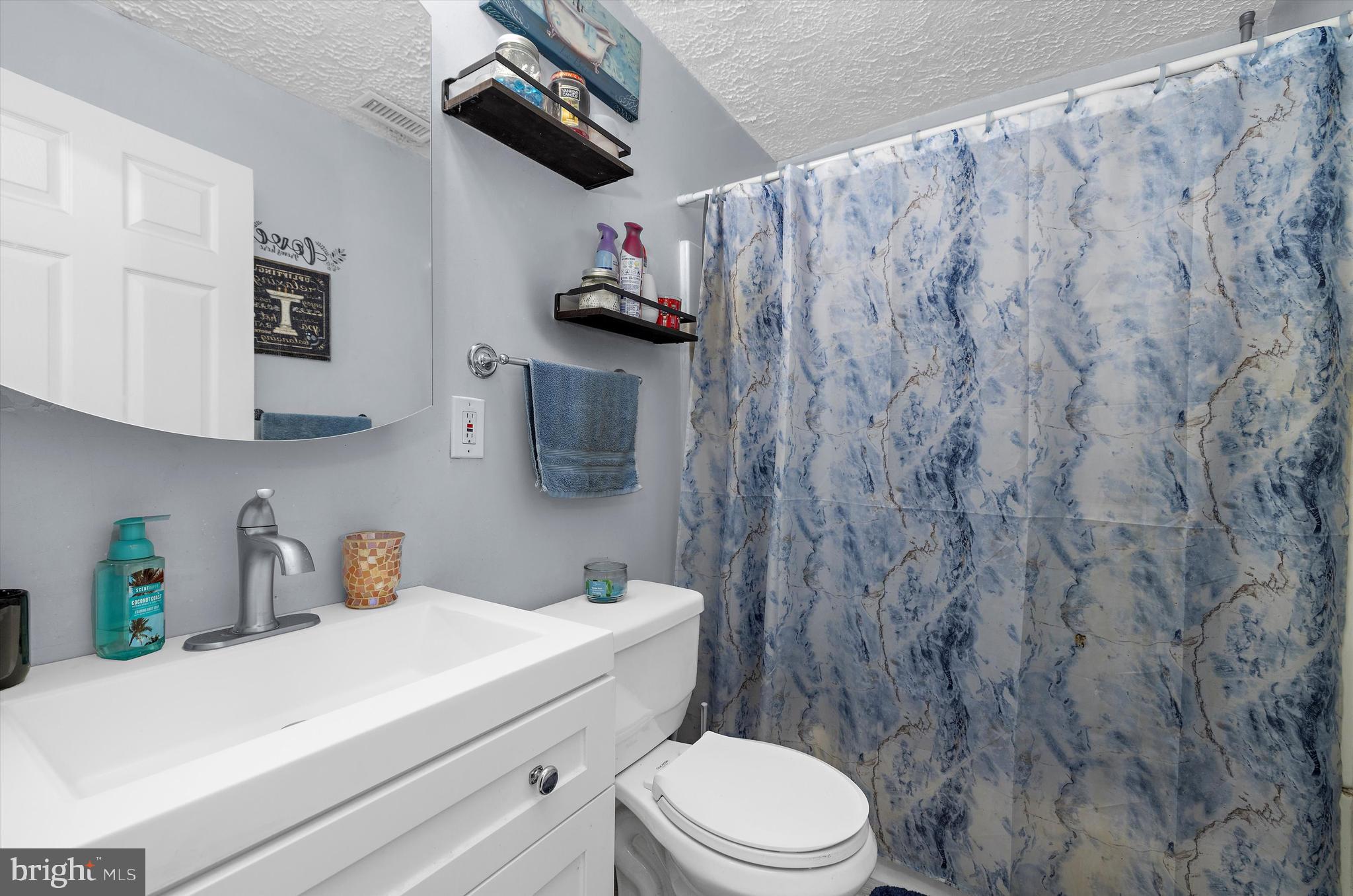 1921 Norwich Road Glen Burnie, MD 21061 - Photo 13 of 37 a bathroom with a sink a toilet and shower curtain