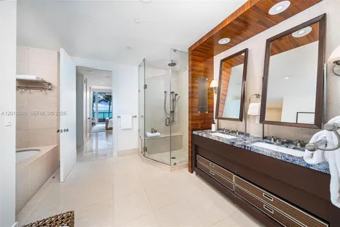 a bathroom with a granite countertop sink mirror bathtub and shower