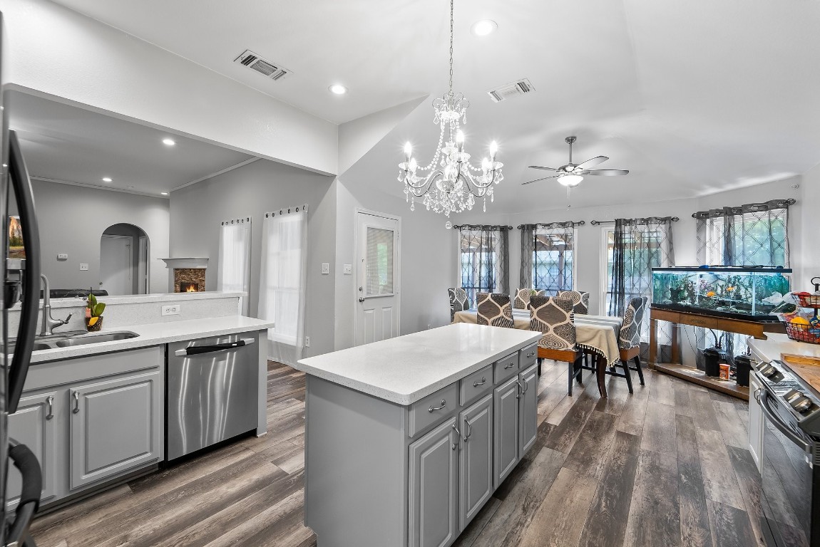 a large white kitchen with lots of counter space and chandelier
