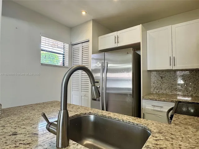 a kitchen with stainless steel appliances granite countertop a refrigerator