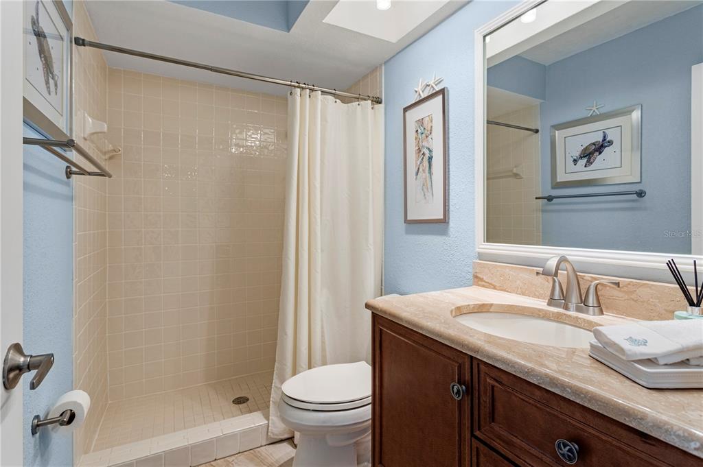 911 Harbour House Drive Indian Rocks Beach, FL 33785 - Photo 18 of 27 a bathroom with a granite countertop sink toilet and shower
