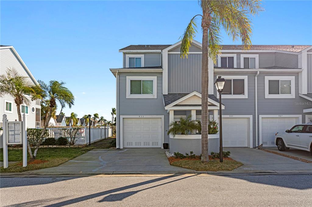 911 Harbour House Drive Indian Rocks Beach, FL 33785 - Photo 23 of 27 a front view of a house with a garden