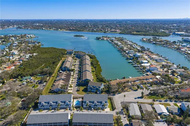 an aerial view of a city with lots of residential buildings and ocean view in back