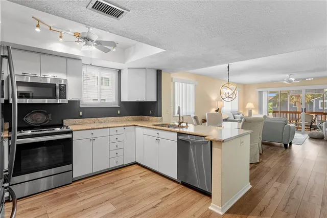 a kitchen with a sink cabinets and wooden floor