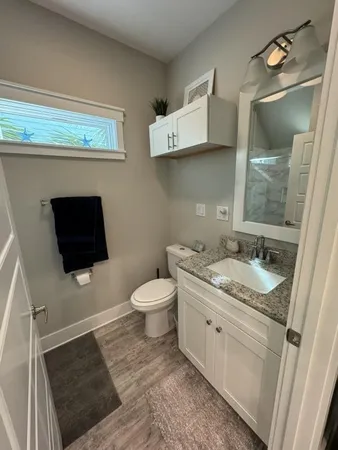 a bathroom with a granite countertop toilet sink and mirror