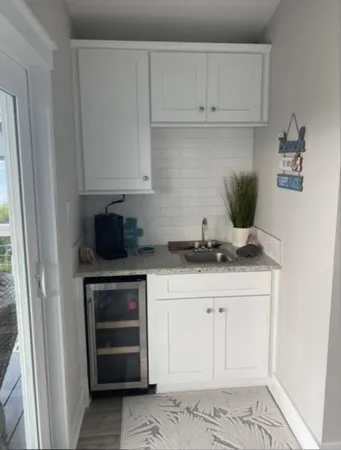 a kitchen with granite countertop a stove and a white cabinets