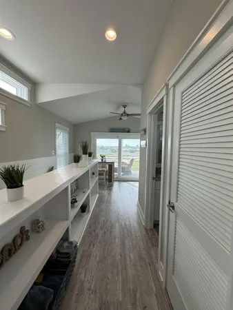 a large white kitchen with a large window a sink and stainless steel appliances