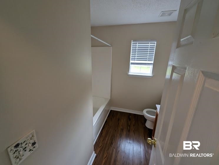 12971 Labradors Run Foley, AL 36535 - Photo 12 of 23 Bathroom featuring wood-finish flooring, a white bathtub, and a window with blinds