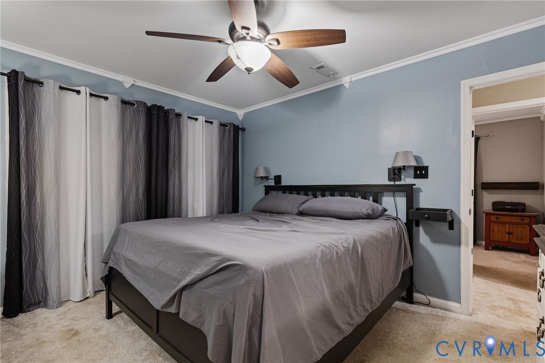 15601 Roland View Drive Chester, VA 23831 - Photo 13 of 18 a spacious bedroom with a bed and a chandelier