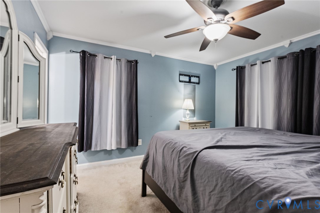 15601 Roland View Drive Chester, VA 23831 - Photo 14 of 18 a bedroom with a large bed and a chandelier