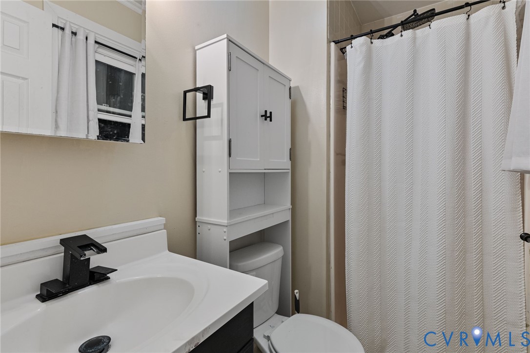 15601 Roland View Drive Chester, VA 23831 - Photo 10 of 18 a bathroom with a sink a toilet and shower curtain