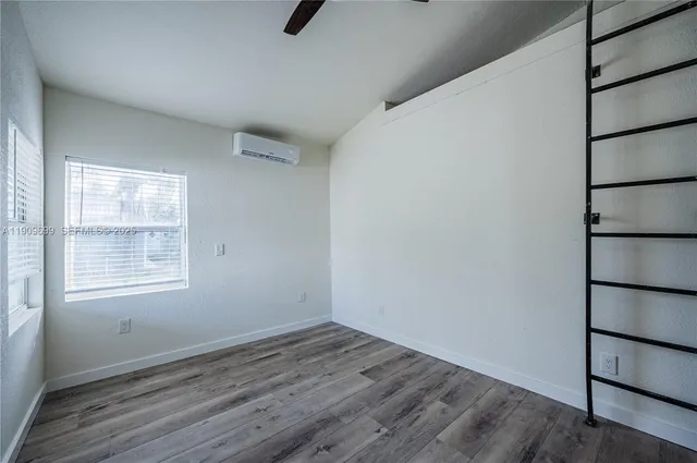 an empty room with a wooden floor and a window