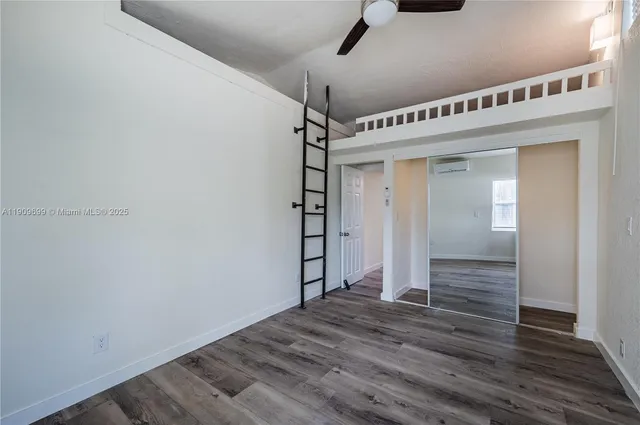 a view of a big room with wooden floor closet and windows