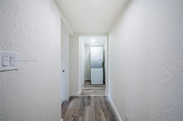 a view of a room with wooden floor and a hallway