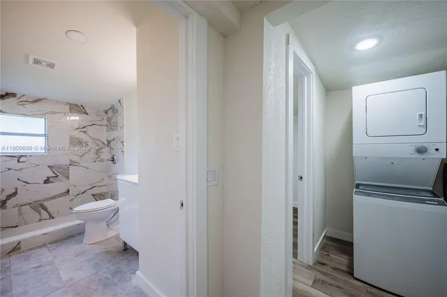 a bathroom with a granite countertop toilet and a shower