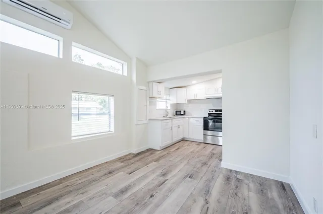 a view of a kitchen with wooden floor and electronic appliances