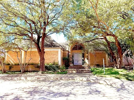 a view of a house with a yard covered in snow