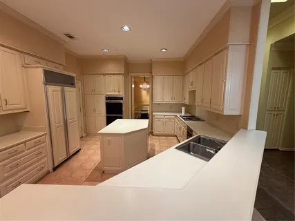a living room with stainless steel appliances furniture a rug and a window