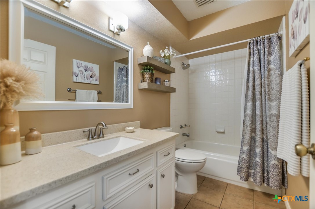 60 Crazy Cross Road Wimberley, TX 78676 - Photo 11 of 20 Bathroom features a spacious vanity and a neatly tiled shower-tub combination.