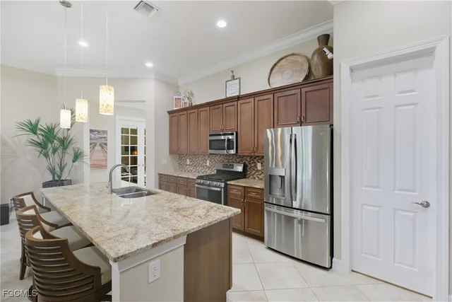 a kitchen with stainless steel appliances granite countertop a sink a stove a refrigerator and a refrigerator