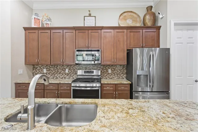 a kitchen with stainless steel appliances granite countertop a sink stove and refrigerator