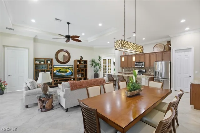 a view of a dining room and livingroom with furniture a rug a fireplace and a chandelier