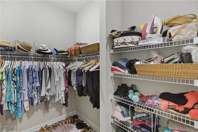 a view of walk in closet with clothes and shoes