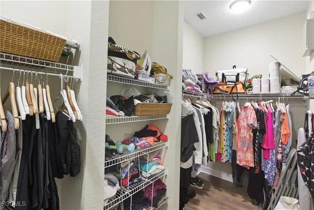 a view of walk in closet with clothes and shoes