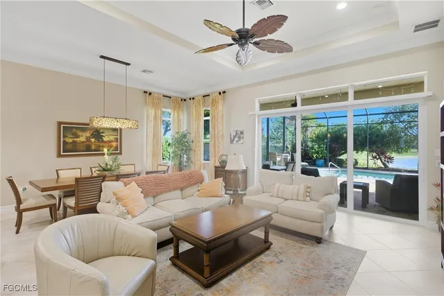 a living room with furniture ceiling fan and a large window
