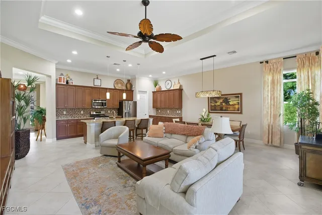 a living room with furniture kitchen view and a window