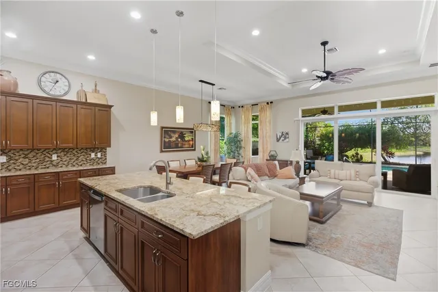 a large kitchen with a large counter top space a sink stainless steel appliances and windows