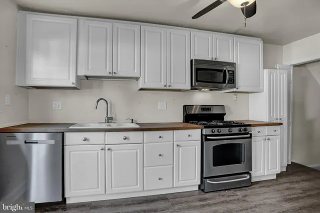 a kitchen with white cabinets and stainless steel appliances