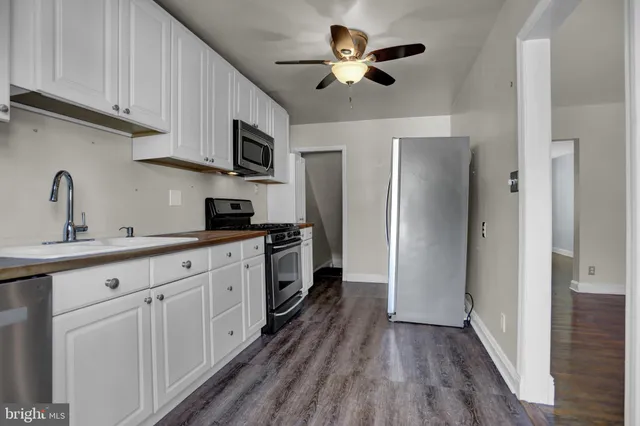 a kitchen with stainless steel appliances a stove a sink and a refrigerator