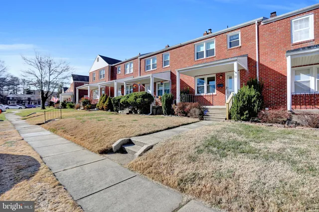a front view of a building with garden and porch