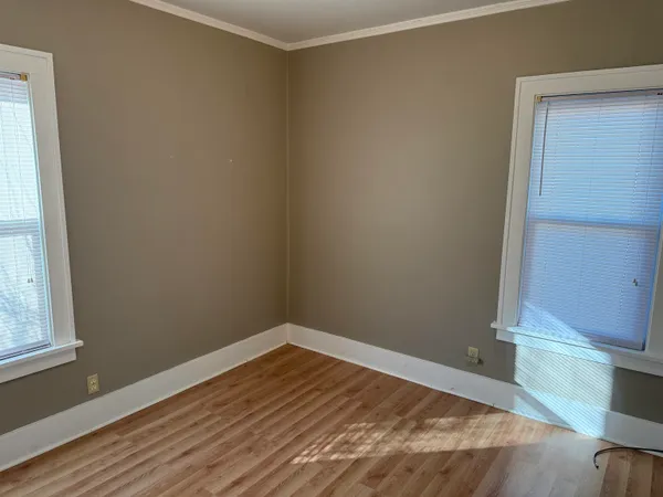 a view of empty room with wooden floor