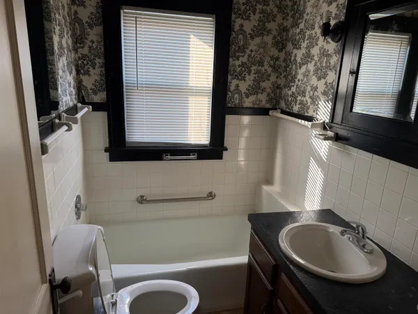 a bathroom with a sink a toilet and a mirror