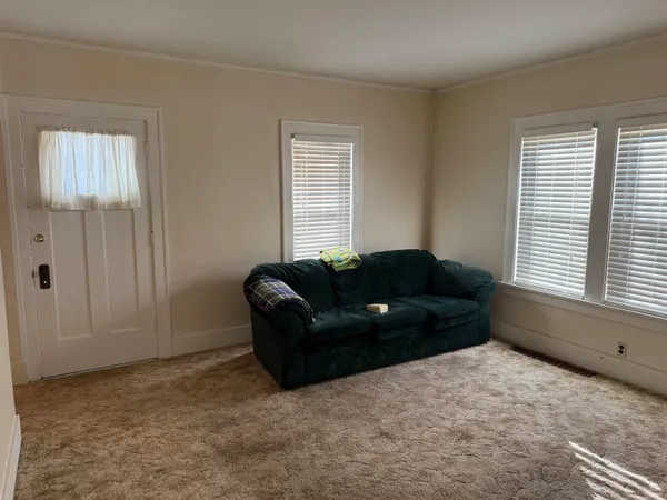 a living room with a couch and a dresser next to a window