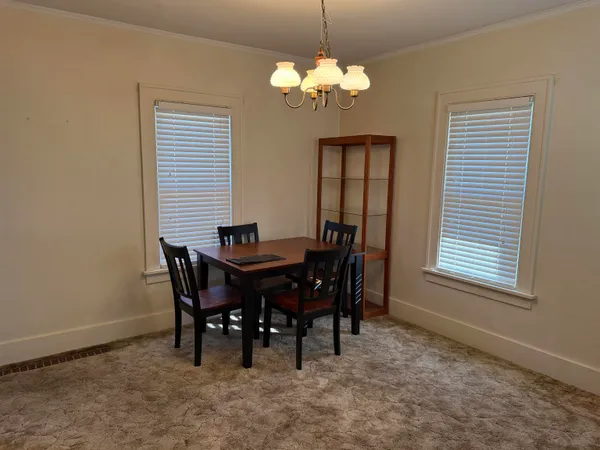 a view of a dining room with furniture and chandelier
