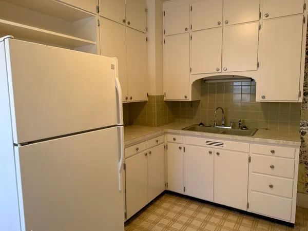 a kitchen with cabinets a refrigerator and a sink
