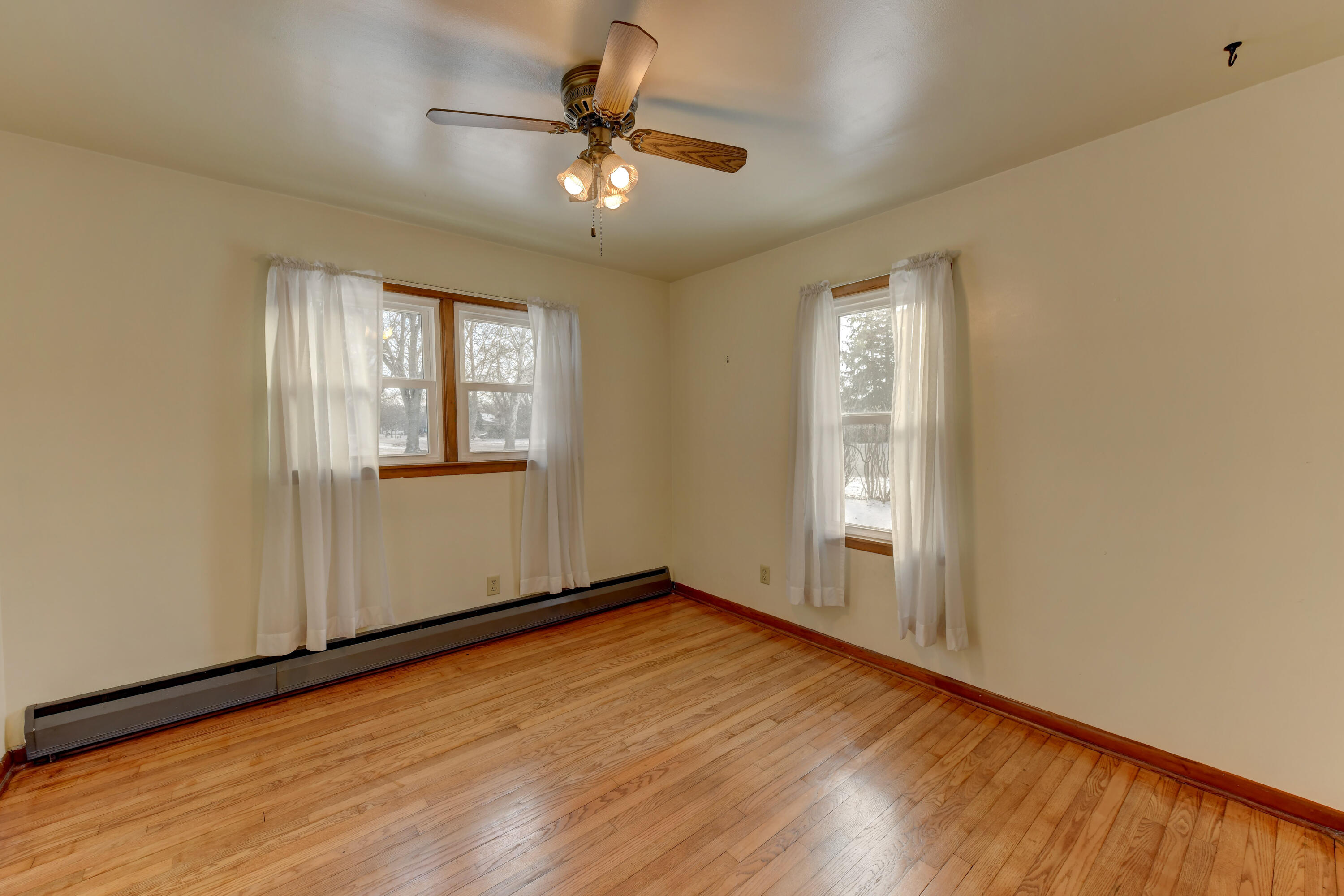 9046 Kleinman Road Highland, IN 46322 - Photo 16 of 20 an empty room with wooden floor chandelier fan and windows