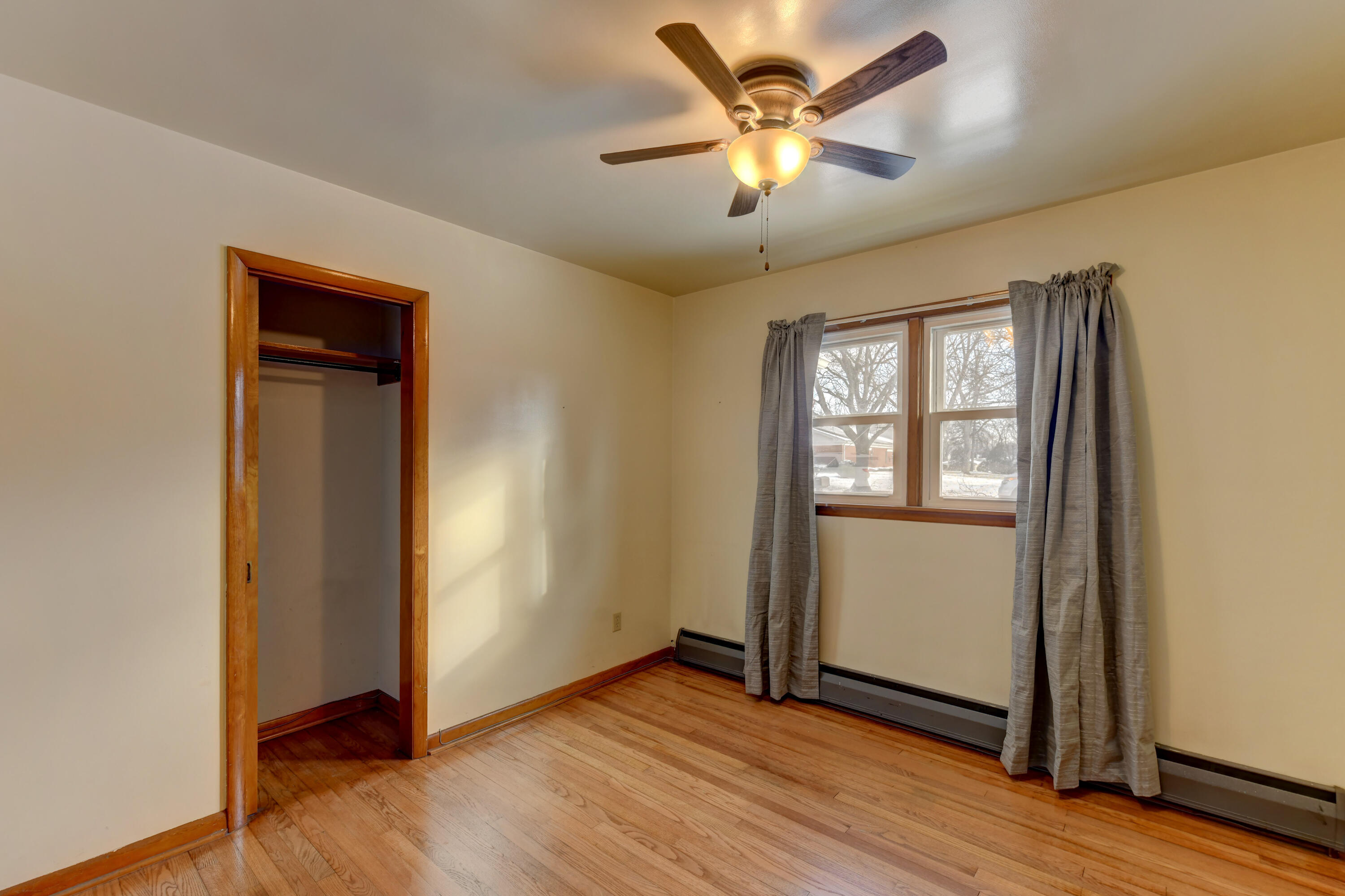 9046 Kleinman Road Highland, IN 46322 - Photo 17 of 20 an empty room with wooden floor and a ceiling fan