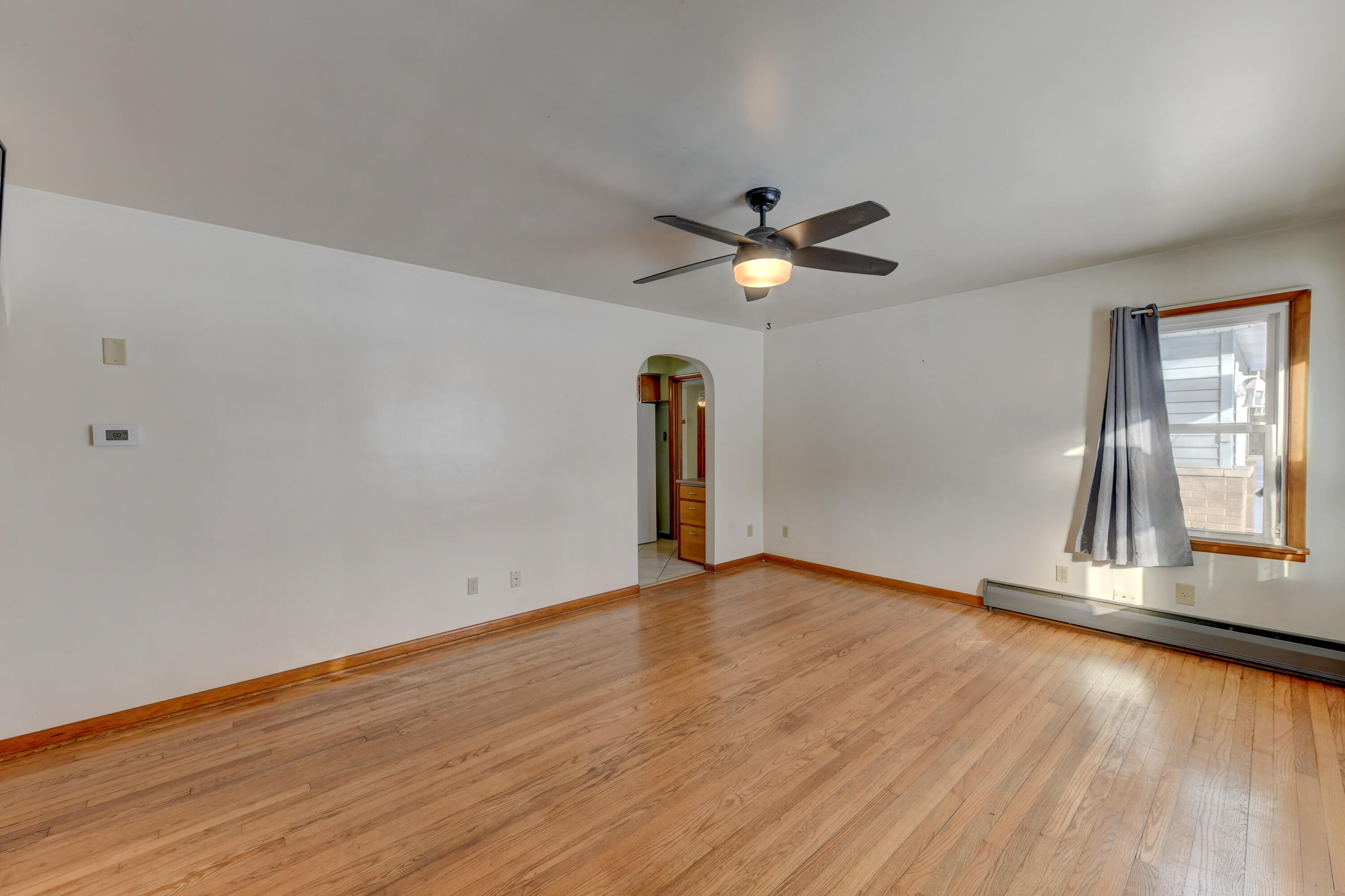 9046 Kleinman Road Highland, IN 46322 - Photo 3 of 20 an empty room with wooden floor and window
