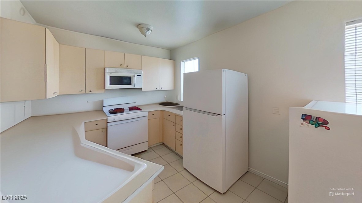 2101 Sun Avenue North Las Vegas, NV 89030 - Photo 9 of 15 Kitchen with white appliances, cream cabinets, light tile patterned floors, and light countertops