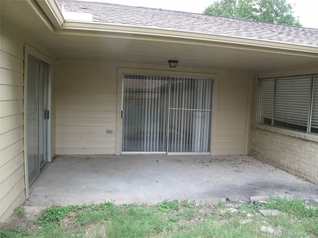 a backyard of a house with lots of plants and large tree