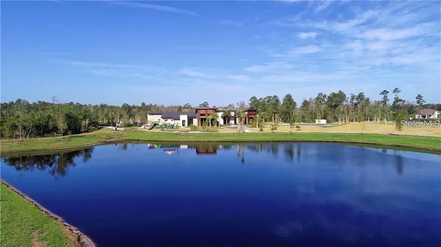 an aerial view of a house with swimming pool and outdoor seating