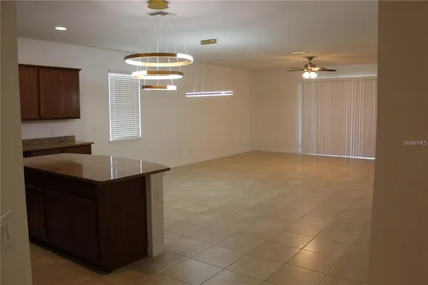 a kitchen with kitchen island a sink stainless steel appliances and chandelier
