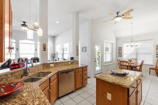 a large kitchen with kitchen island a stove a sink a dining table and chairs