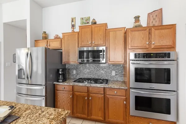 a kitchen with stainless steel appliances granite countertop a refrigerator stove and oven