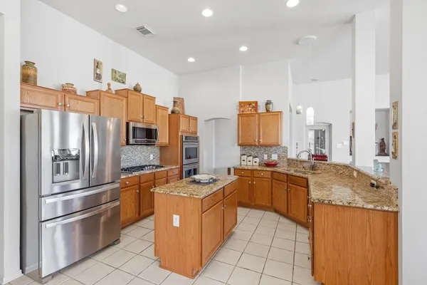 a kitchen with stainless steel appliances granite countertop a sink stove and refrigerator